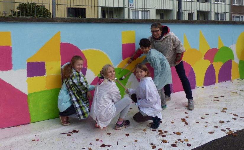 Schulmauer der Grundschule Annastraße leuchtet in bunten Farben